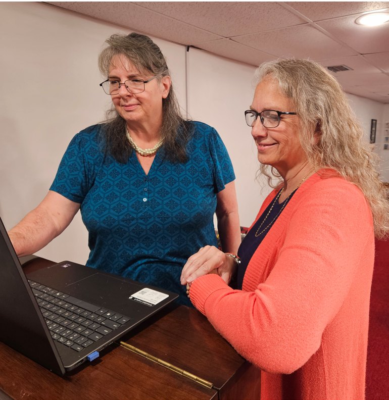 Linda Hubatsek walking a business owner through her books on a laptop.